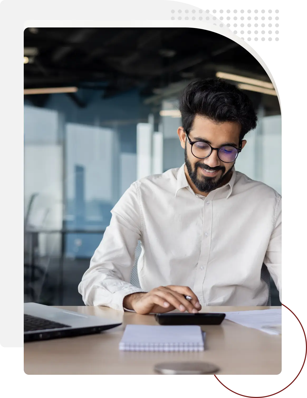 A man in glasses is using his laptop