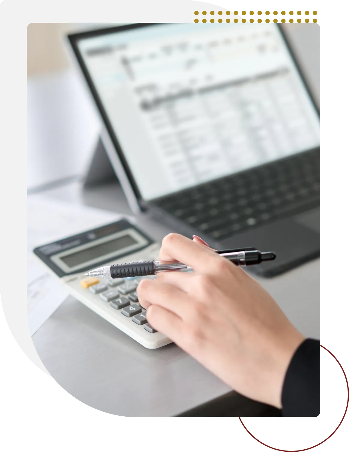 A person using a calculator on top of a desk.